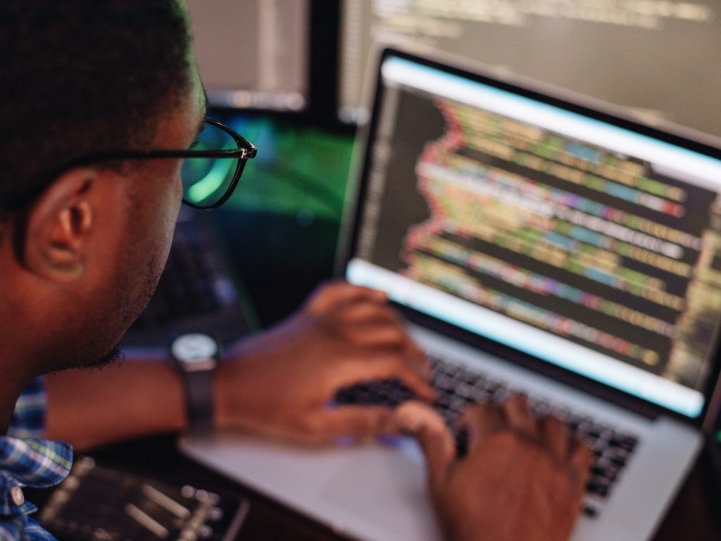 black-male-in-front-of-computer-screen-coding-mobile-app-web-development-computer-programming.jpg
